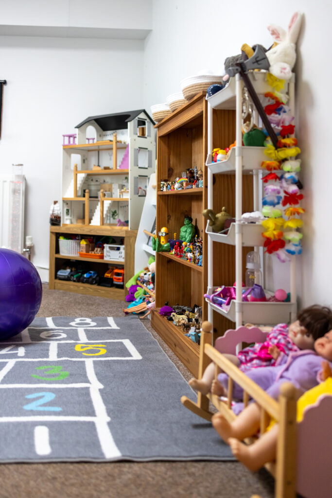Wide view of the Play Lab playroom with dollhouse and toy shelves