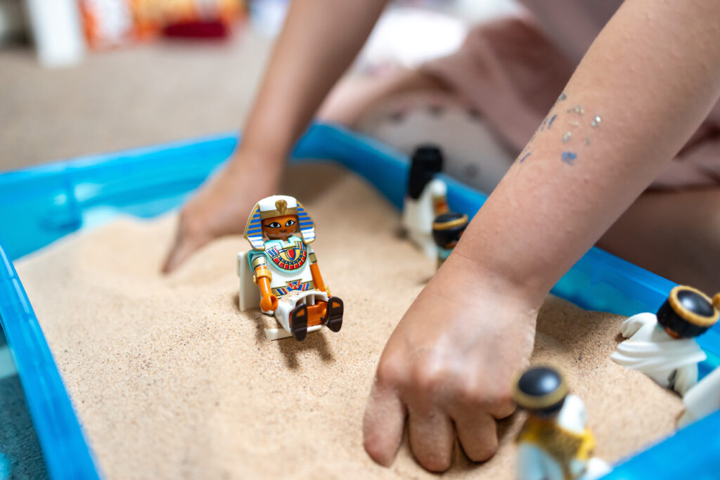 Child using figures in a sand tray